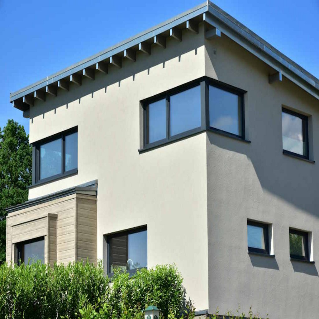 Eckfenster in anthrazit mit grauer Fassade und blauem Himmel