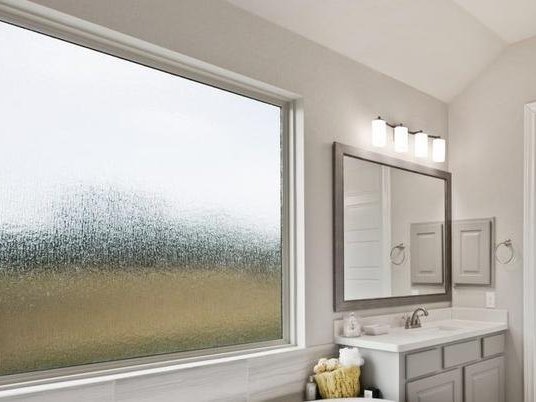 weißes Fenster mit Ornamentglas im Badezimmer