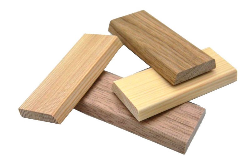 vier natur lackierte Holzstücke aus unterschiedlichen Holzarten